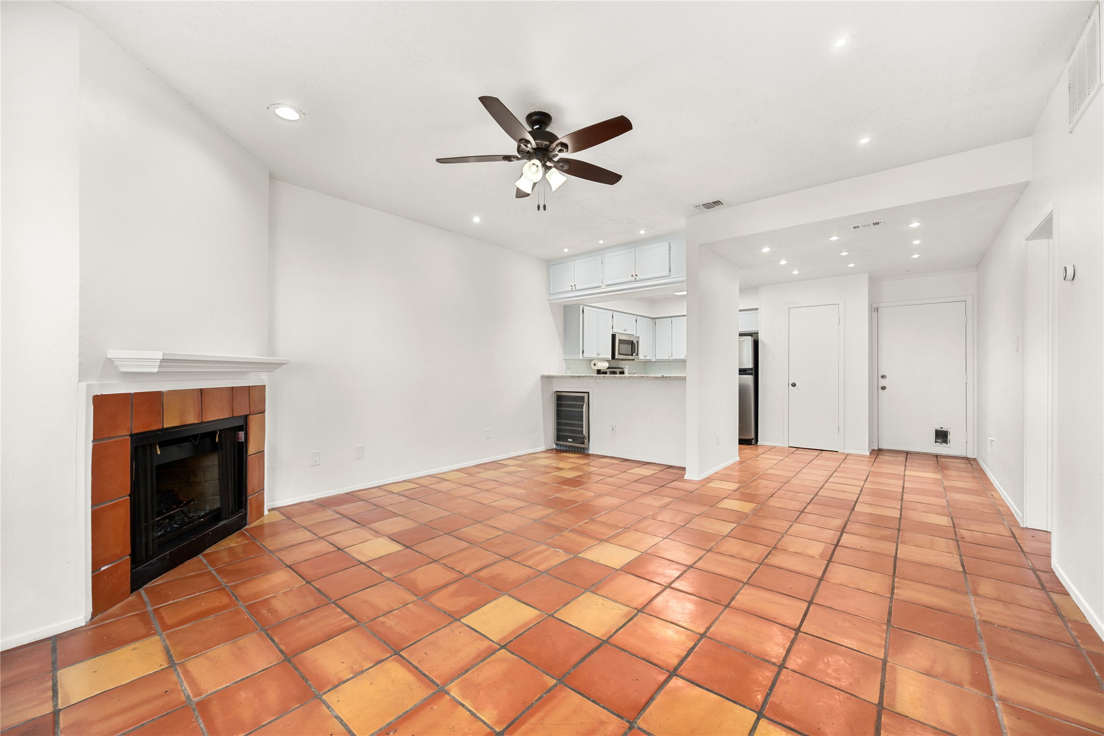 1501 Barton Springs Road, Unit 118 Austin, TX 78704 - Photo 2 of 23 The living room features a beverage cooler, ceiling fan, and fireplace—creating a comfortable and inviting space to unwind at the end of the day.