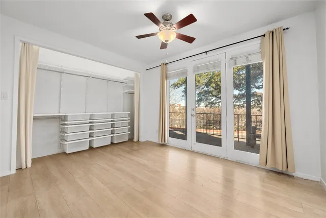 a view of an empty room with a ceiling fan and a window