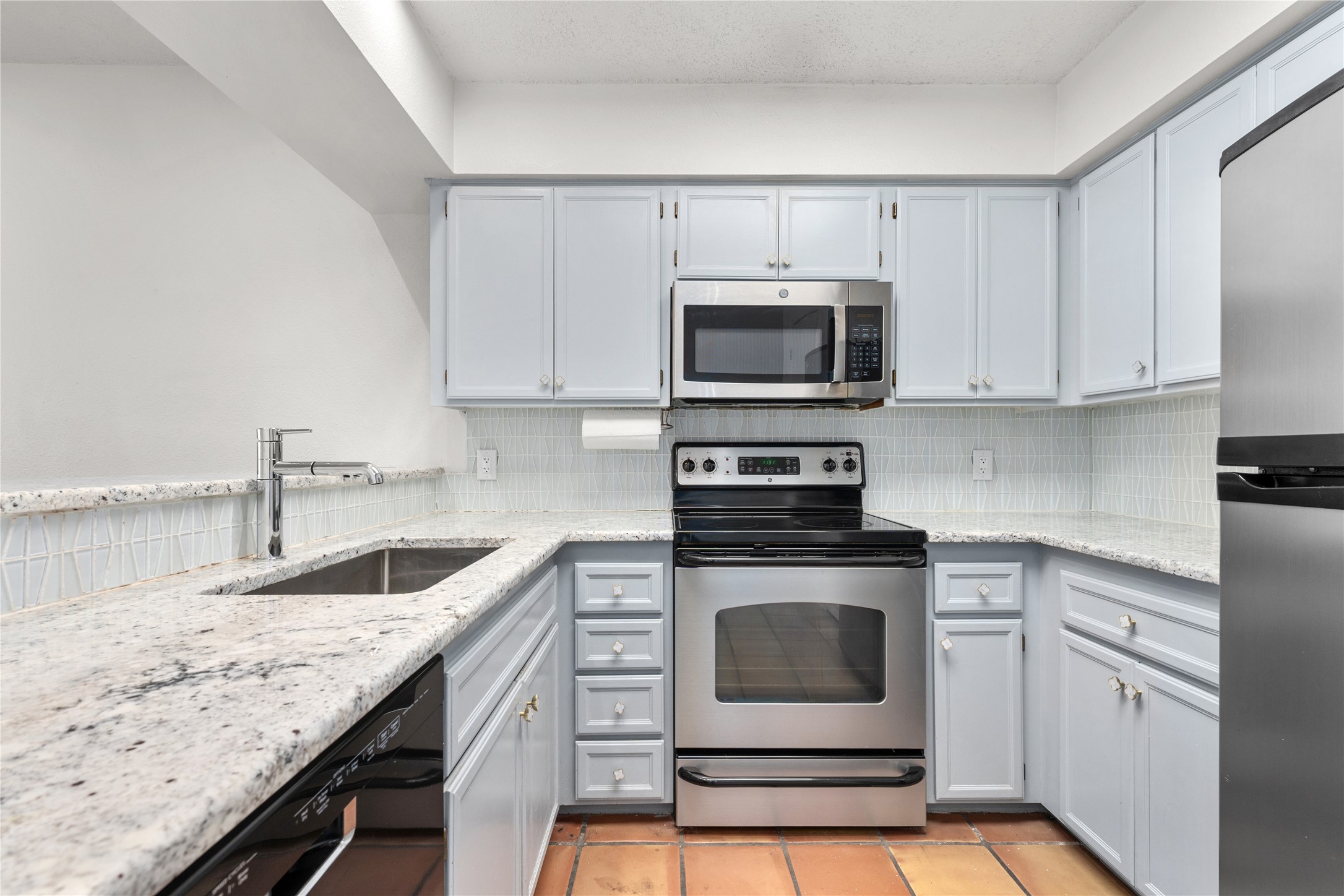 1501 Barton Springs Road, Unit 118 Austin, TX 78704 - Photo 4 of 23 The kitchen showcases stainless steel appliances, sleek gray cabinetry, and a stylish backsplash for a modern, cohesive look.