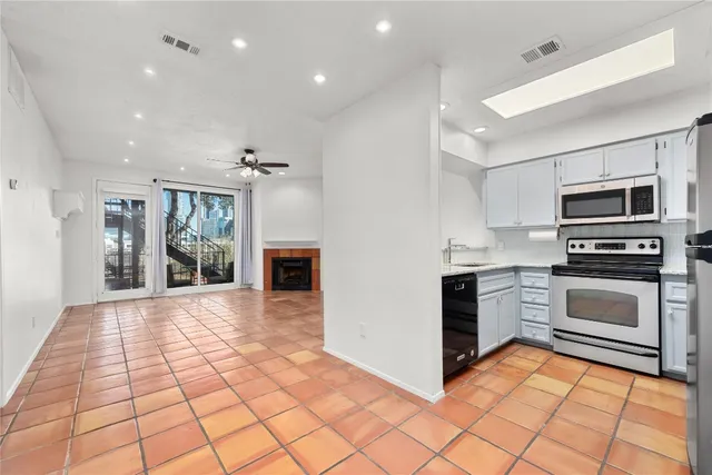 a kitchen with granite countertop a stove top oven and cabinets