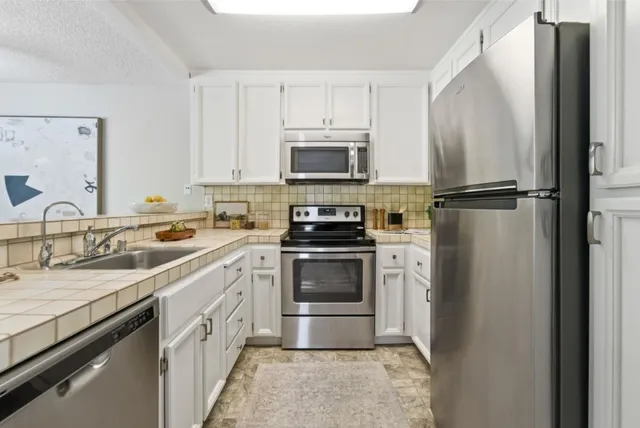 a kitchen with a sink stove and refrigerator