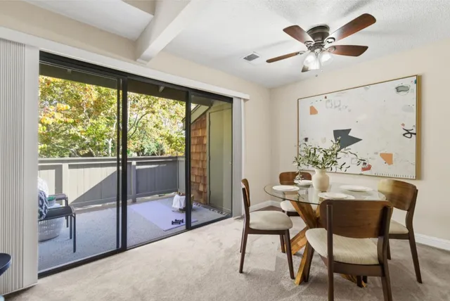 a dining room with furniture a chandelier and a large window