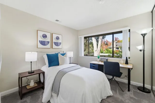 a bedroom with a bed and a table in it with window