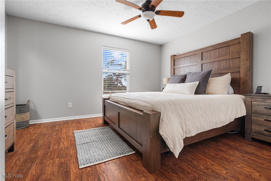 64 River Ridge Lane Munroe Falls, OH 44262 - Photo 12 of 25 Bedroom with a textured ceiling, dark wood-type flooring, and a ceiling fan