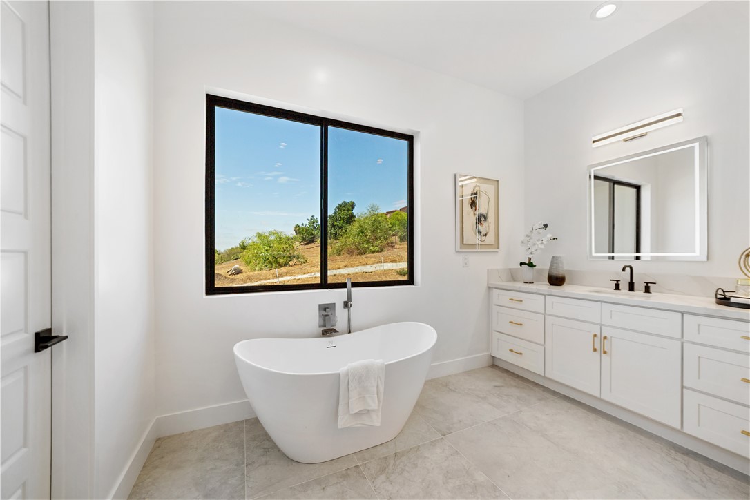 2027 Vía Monserate Fallbrook, CA 92028 - Photo 14 of 66 a bathroom with a sink mirror and a bathtub