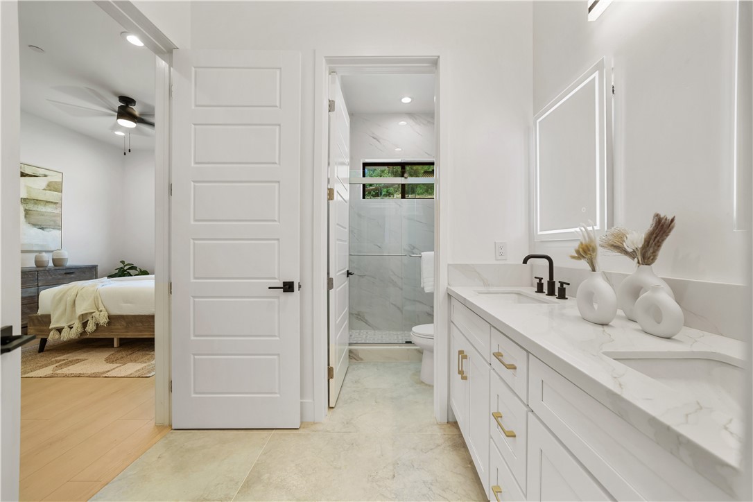 2027 Vía Monserate Fallbrook, CA 92028 - Photo 21 of 66 a en suite bathroom with a double vanity sink a mirror and a shower