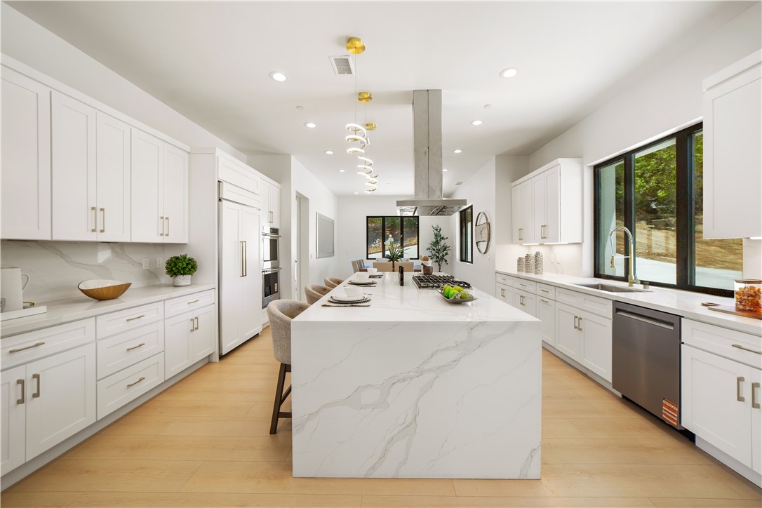 2027 Vía Monserate Fallbrook, CA 92028 - Photo 46 of 66 a kitchen with kitchen island granite countertop lots of white cabinets and stainless steel appliances