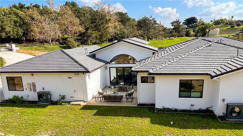 2027 Vía Monserate Fallbrook, CA 92028 - Photo 60 of 66 a view of a white house with a yard and sitting area