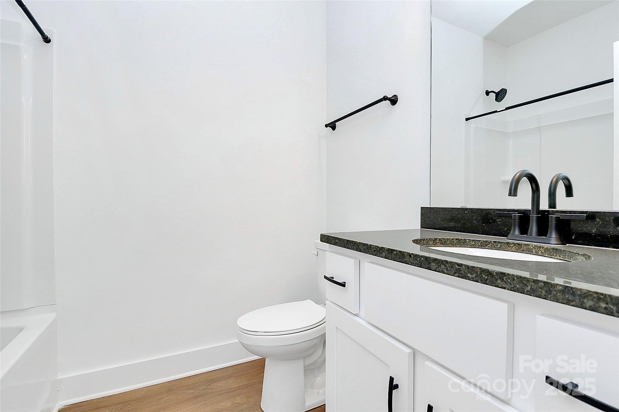 6154 Lowder Road Salisbury, NC 28147 - Photo 16 of 36 a bathroom with a granite countertop sink a toilet and mirror