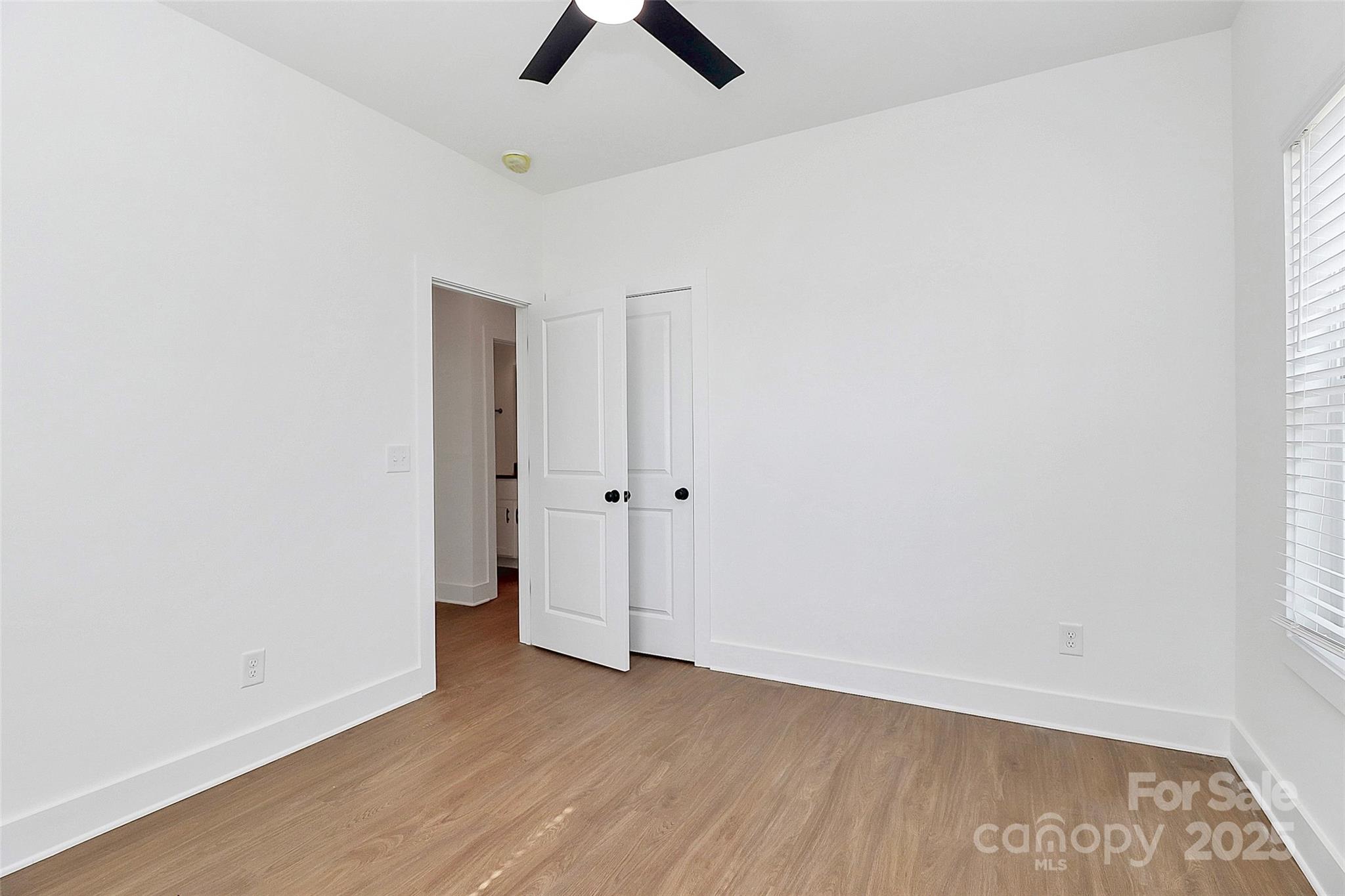 6154 Lowder Road Salisbury, NC 28147 - Photo 18 of 36 an empty room with wooden floor and ceiling fan