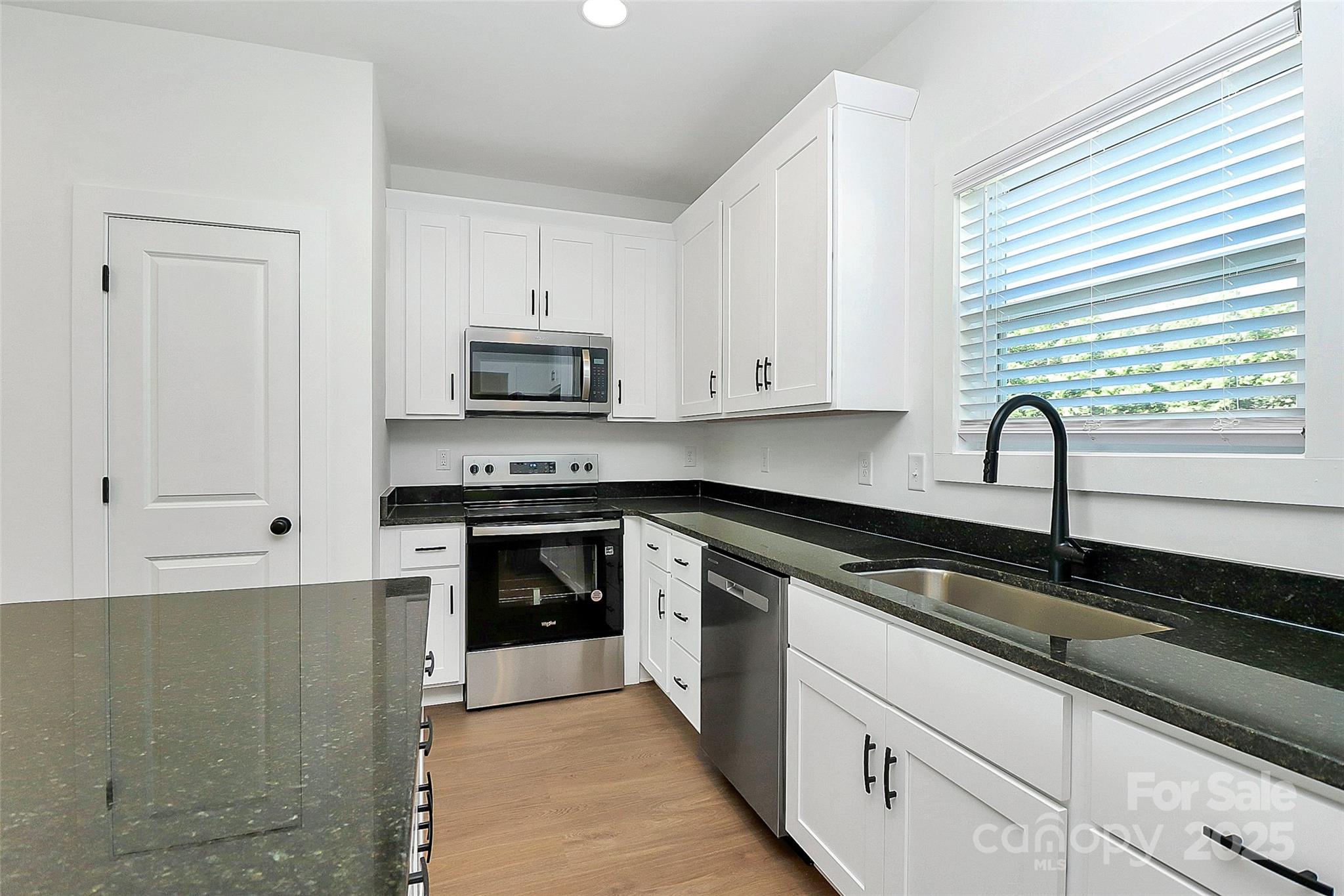 6154 Lowder Road Salisbury, NC 28147 - Photo 10 of 36 a kitchen with granite countertop white cabinets and black appliances