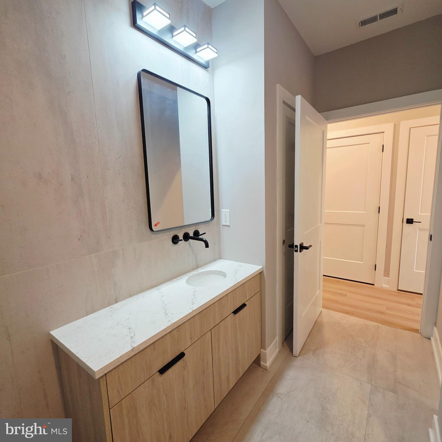 714 Chestnut Street, Unit 3F Philadelphia, PA 19106 - Photo 11 of 16 a bathroom with a sink a mirror and a vanity