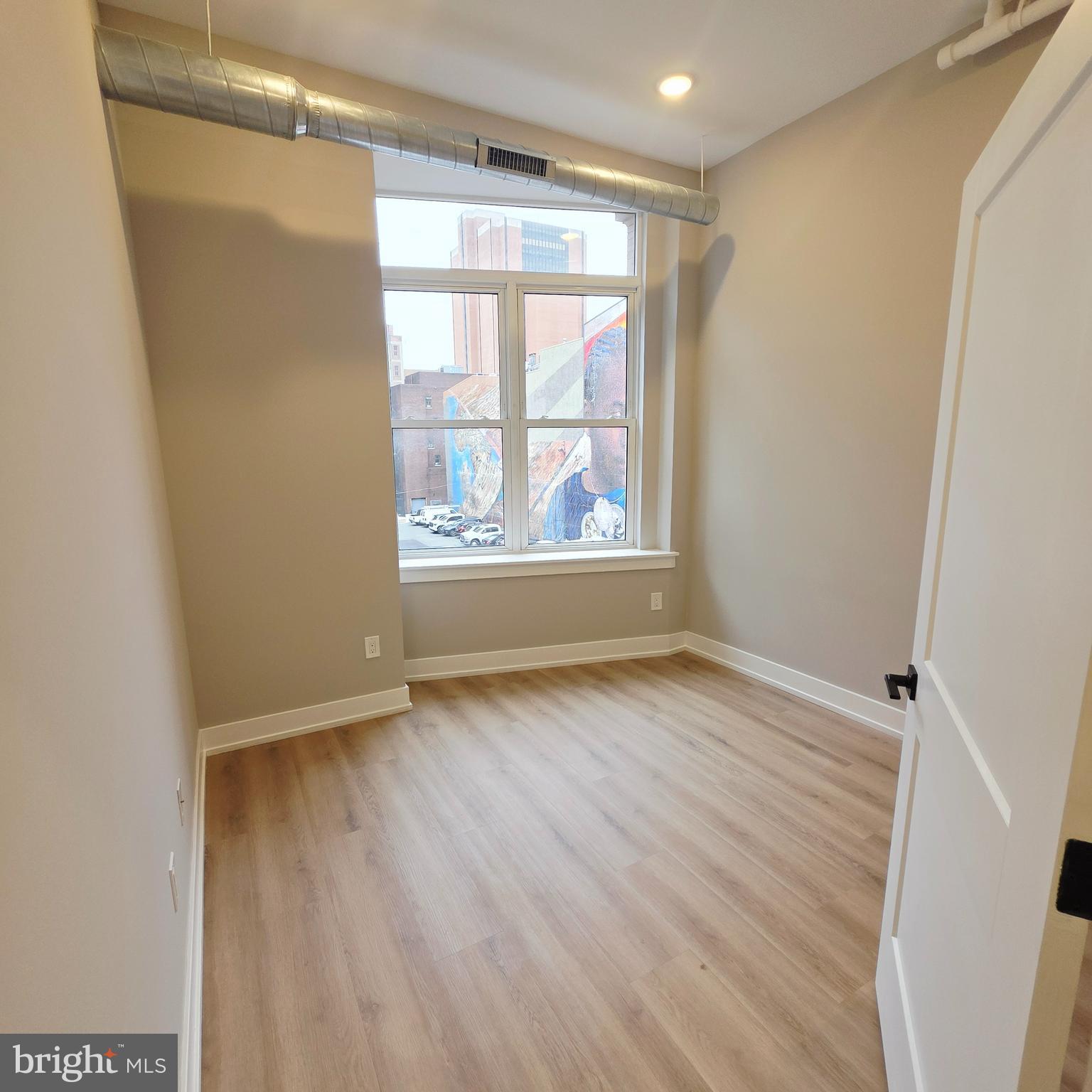 714 Chestnut Street, Unit 3F Philadelphia, PA 19106 - Photo 10 of 16 an empty room with wooden floor and windows