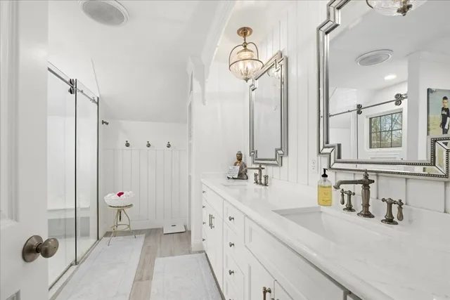 a bathroom with a double vanity sink mirror and shower