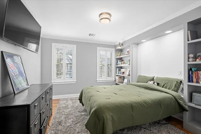 a spacious bedroom with a bed a flat screen tv and a window