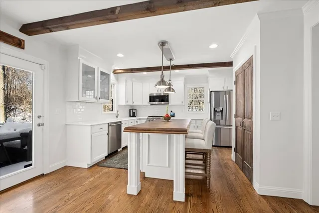 a kitchen with stainless steel appliances a kitchen island hardwood floor sink and stove