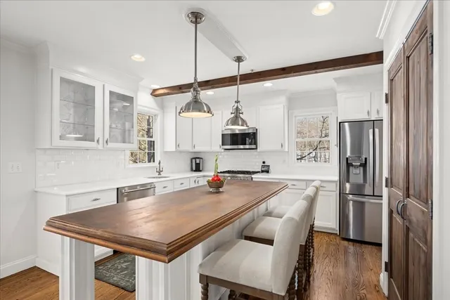 a kitchen with a table a refrigerator a sink and cabinets