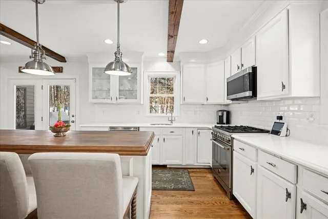 a kitchen with stainless steel appliances granite countertop a sink stove and cabinets