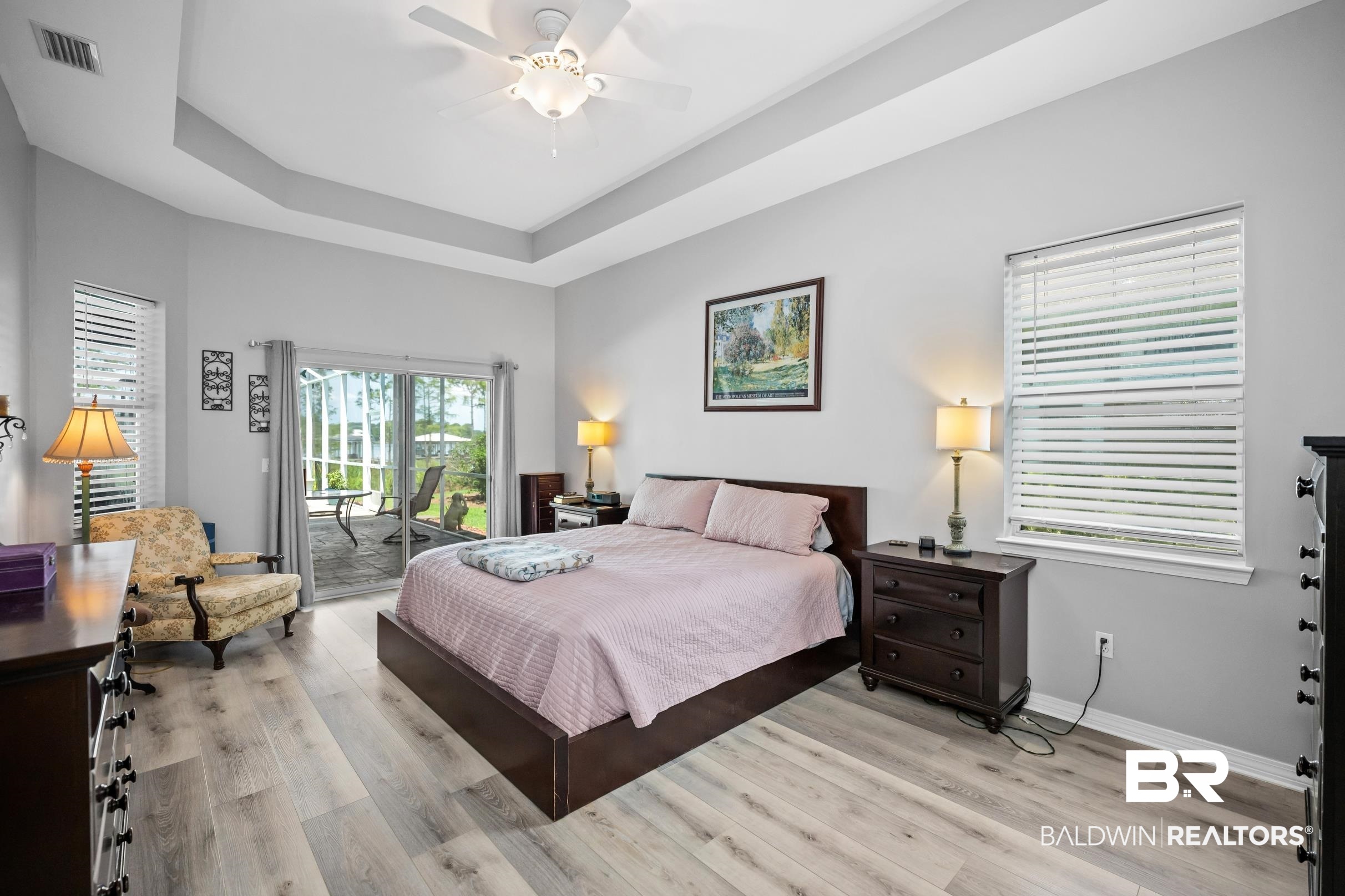 8585 Bay Harbor Road Elberta, AL 36530 - Photo 21 of 51 Bedroom with access to exterior, light wood-style floors, a tray ceiling, and ceiling fan