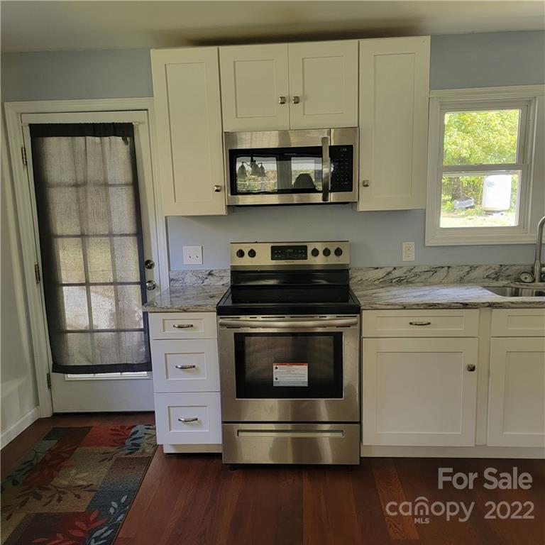 26 Possum Trot Road Bakersville, NC 28705 - Photo 12 of 22 a kitchen with stainless steel appliances a stove a sink and a microwave