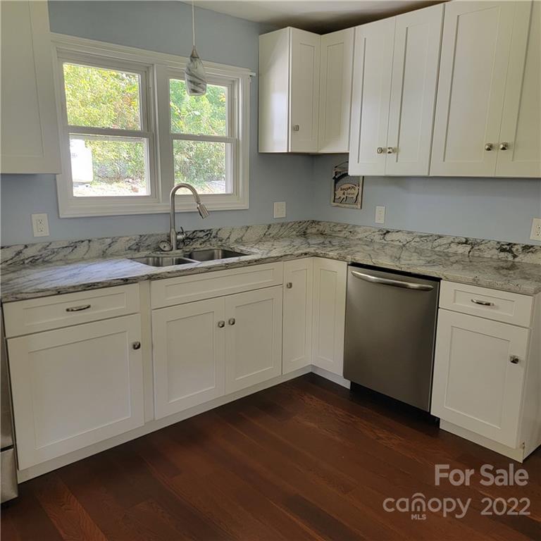 26 Possum Trot Road Bakersville, NC 28705 - Photo 13 of 22 a kitchen with granite countertop stainless steel appliances white cabinets granite counter tops and a wooden floors