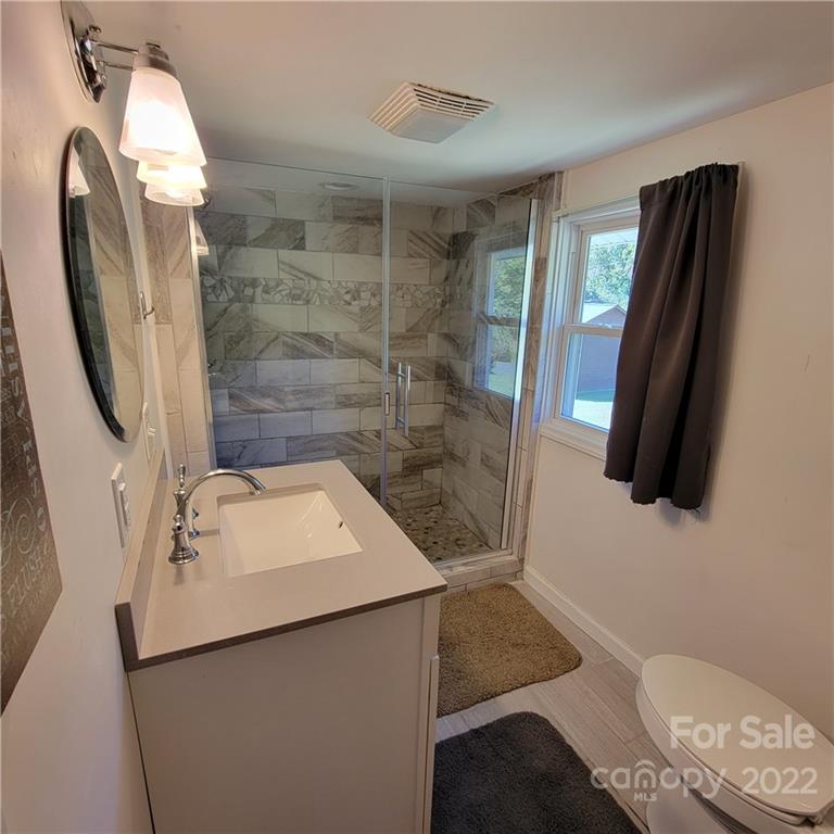 26 Possum Trot Road Bakersville, NC 28705 - Photo 17 of 22 a bathroom with a sink a toilet a mirror and shower