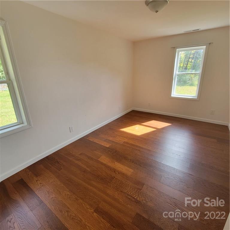 26 Possum Trot Road Bakersville, NC 28705 - Photo 19 of 22 an empty room with wooden floor and windows