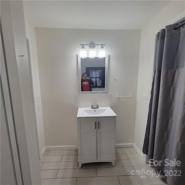 26 Possum Trot Road Bakersville, NC 28705 - Photo 22 of 22 a bathroom with a sink a mirror and a shower