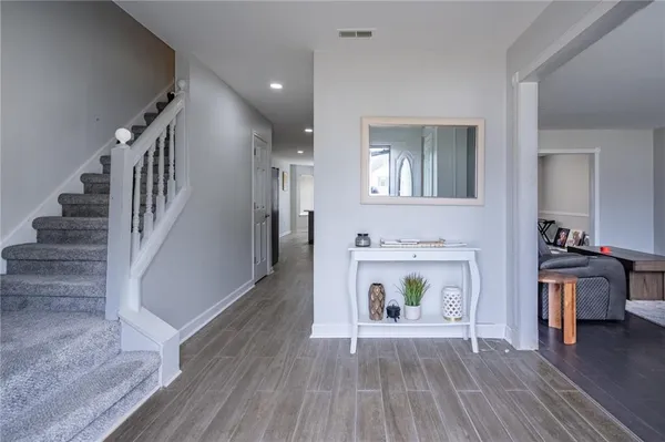 a view of a livingroom with wooden floor and a fireplace