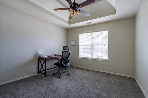 a view of a workspace with furniture and a window
