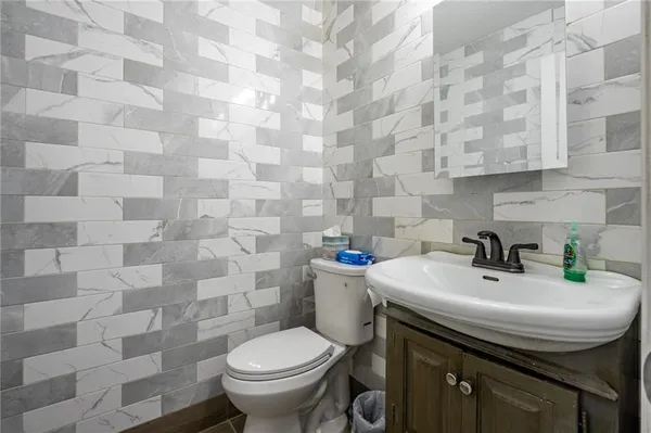 a bathroom with a sink a toilet and a mirror