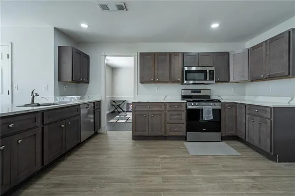 a kitchen with stainless steel appliances granite countertop a stove a sink dishwasher a refrigerator and a oven