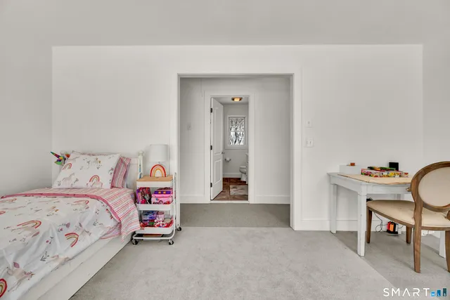 a bedroom with a bed and a chair in it