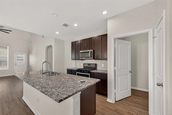 a kitchen with granite countertop a sink and wooden cabinets