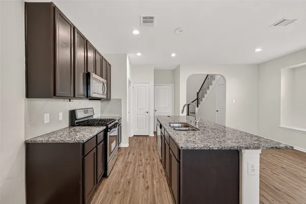 a kitchen with stainless steel appliances granite countertop a sink stove and cabinets