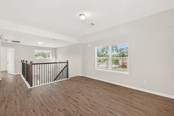 an empty room with wooden floor and window