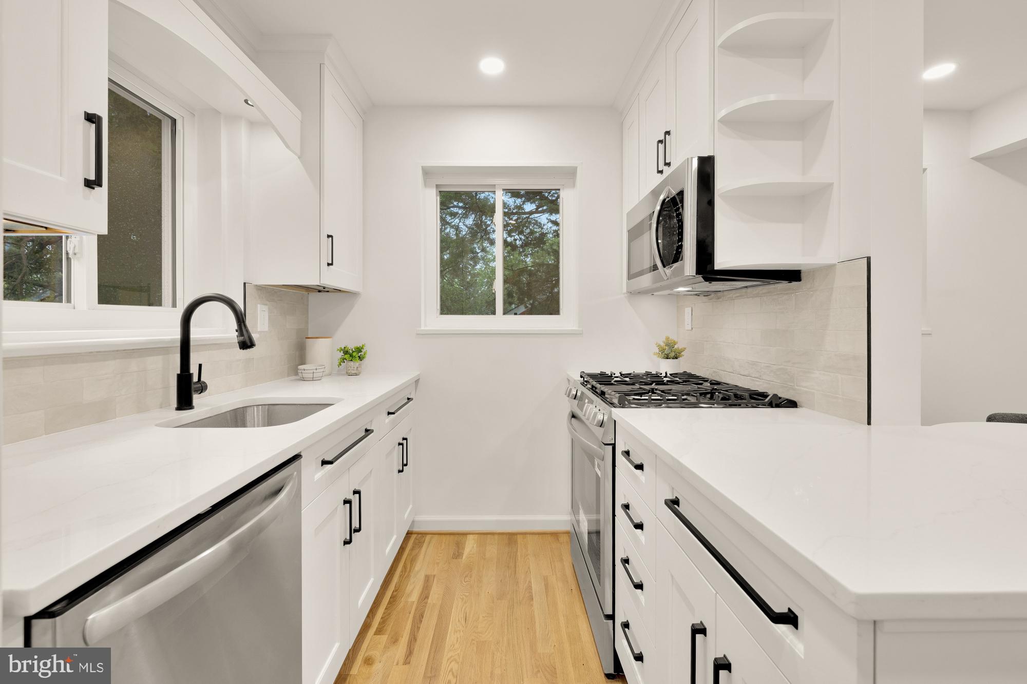 6232 18th Road North Arlington, VA 22205 - Photo 13 of 43 a kitchen with white cabinets a sink dishwasher and a stove with wooden floor