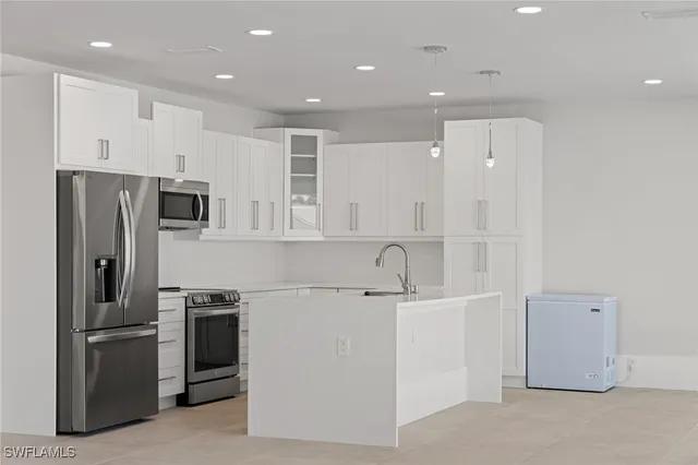 a view of a kitchen with stainless steel appliances wooden floor and windows