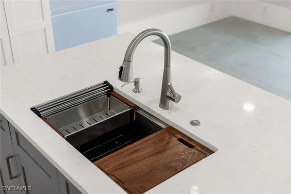 a close view of a sink and dishwasher with wooden floor