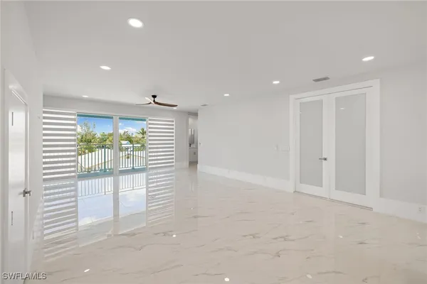 a large white kitchen with stainless steel appliances