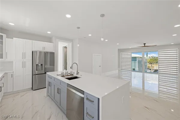 a kitchen with white cabinets and sink