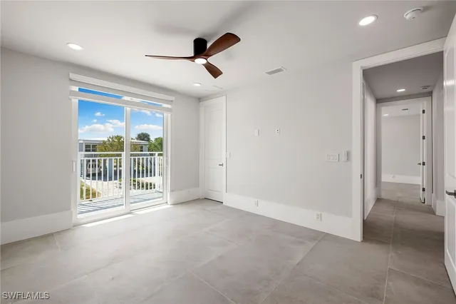 an empty room with fan and windows