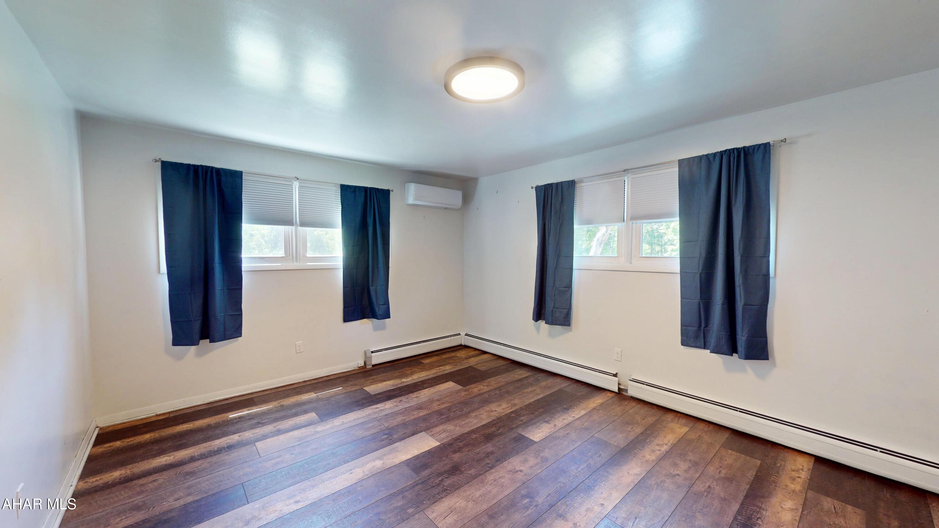 871 Decker Hollow Road Tyrone, PA 16686 - Photo 22 of 35 an empty room with wooden floor and windows