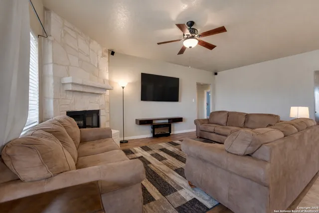 a living room with furniture a fireplace and a flat screen tv