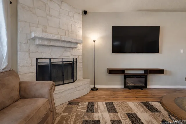 a living room with a fireplace and a flat screen tv