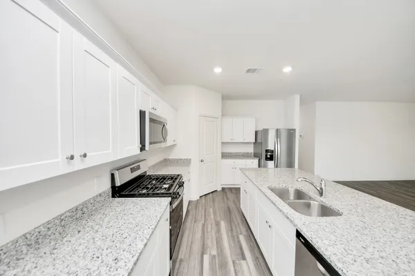 a kitchen with stainless steel appliances granite countertop a sink stove and refrigerator