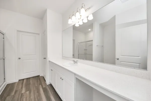 a spacious bathroom with a granite countertop sink a mirror and a shower