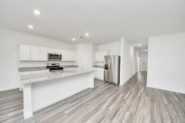 a large white kitchen with stainless steel appliances