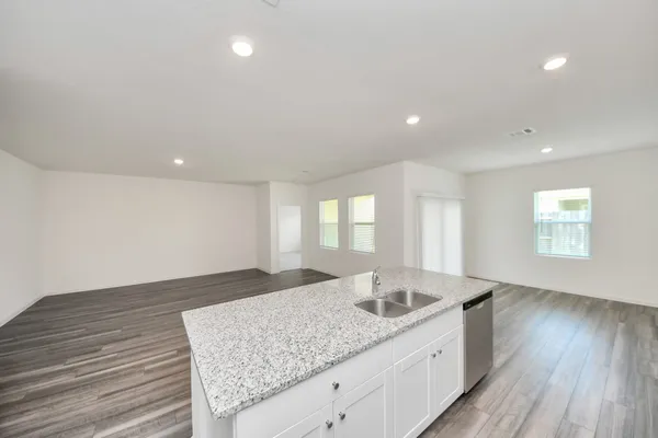 a kitchen with a sink and wooden floor