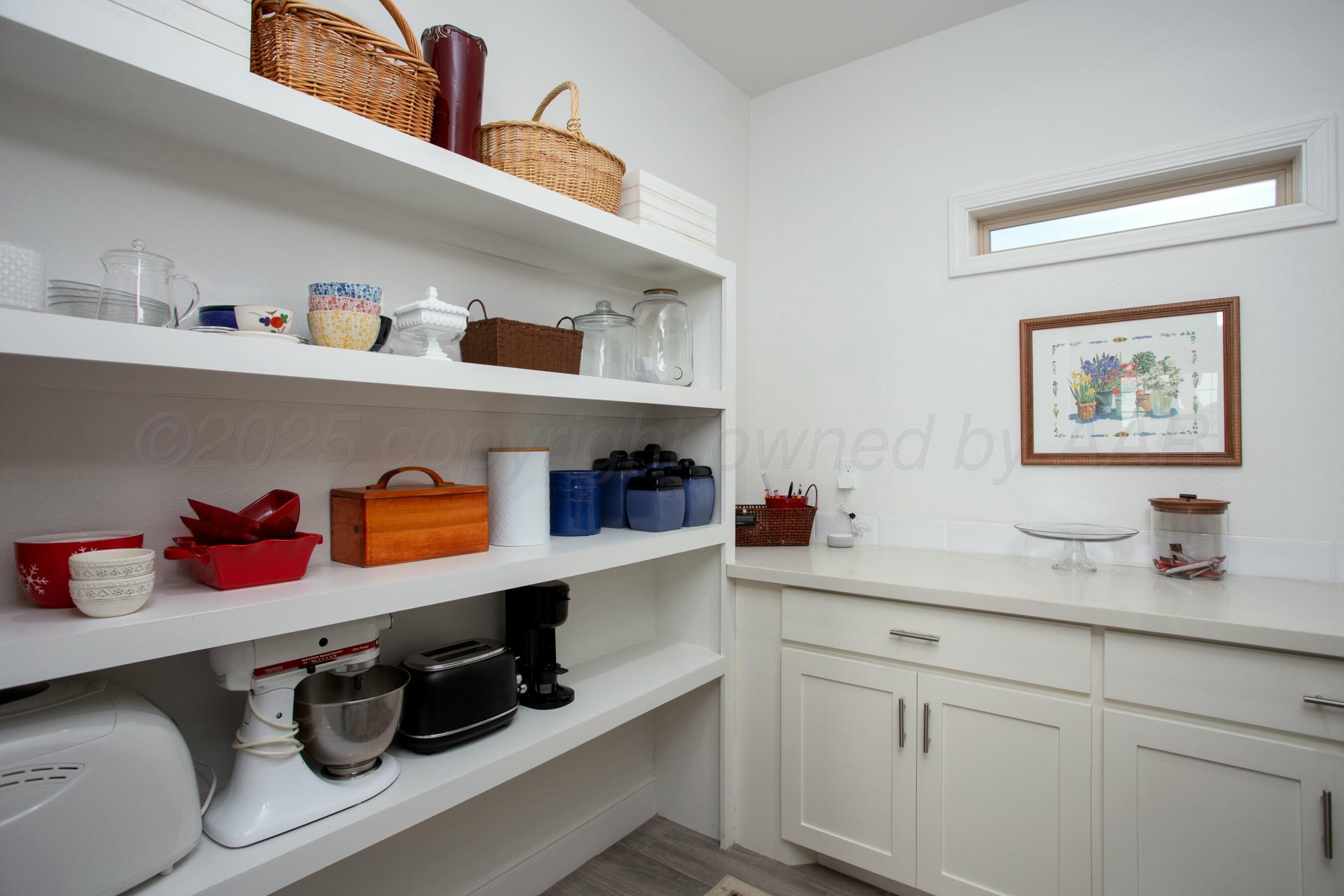 18501 Helium Road Canyon, TX 79015 - Photo 12 of 28 a kitchen with white cabinets and a wooden floor
